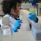 Someone from the lab is looking at a tube