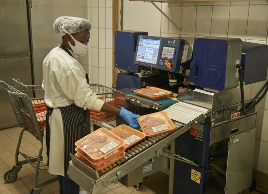 A woman is weighing the meat
